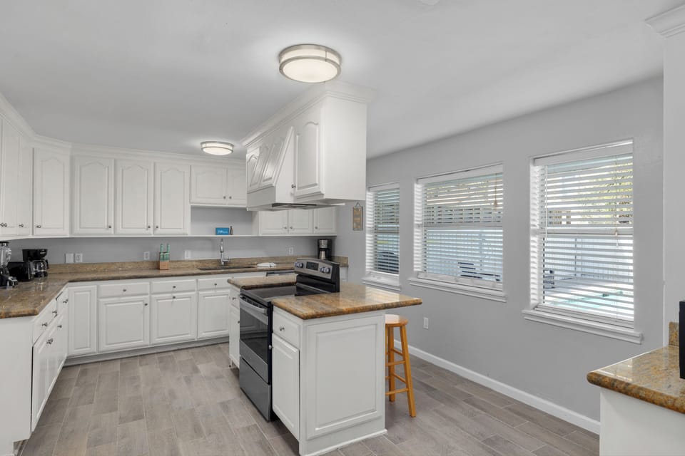Large kitchen with additional bar seating and stainless steel appliances