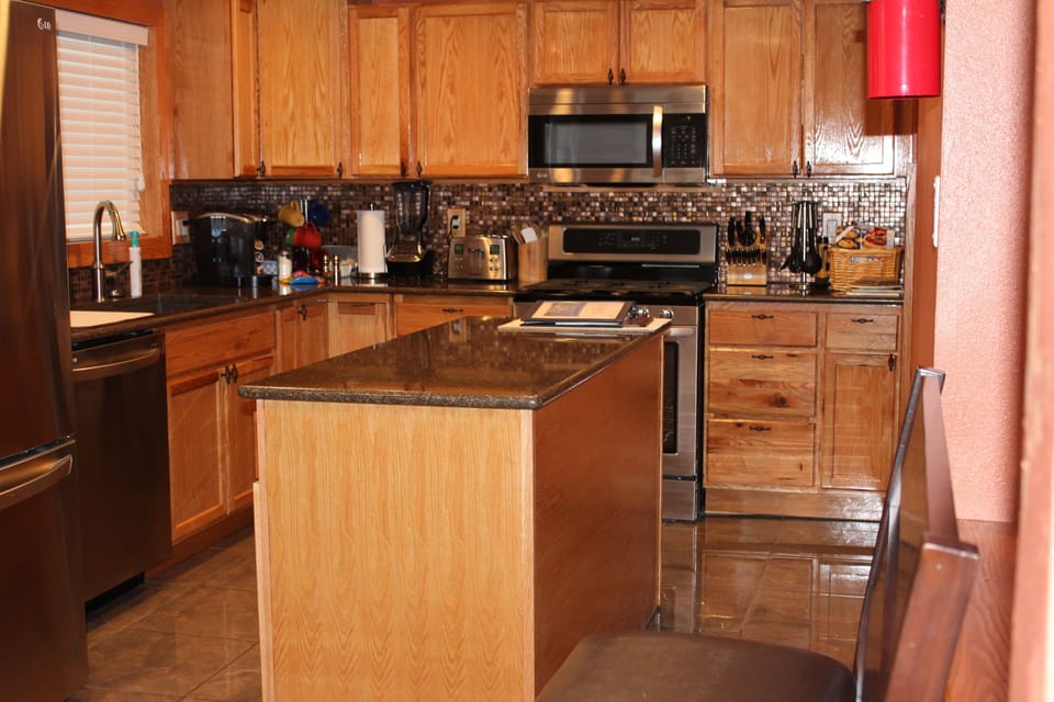 Remodeled kitchen showing movable island in center of kitchen.

