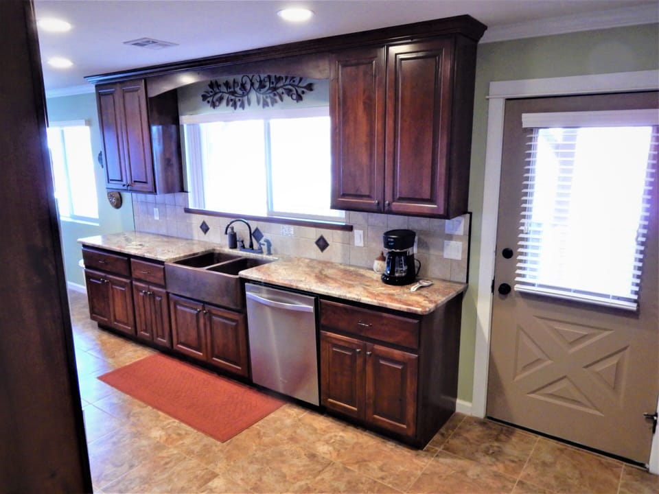 Double copper sink, dishwasher and door to spacious deck  