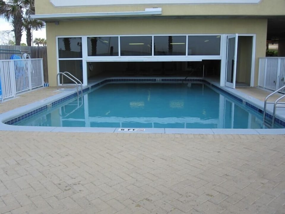 Covered pool area with tables and lounge chairs!