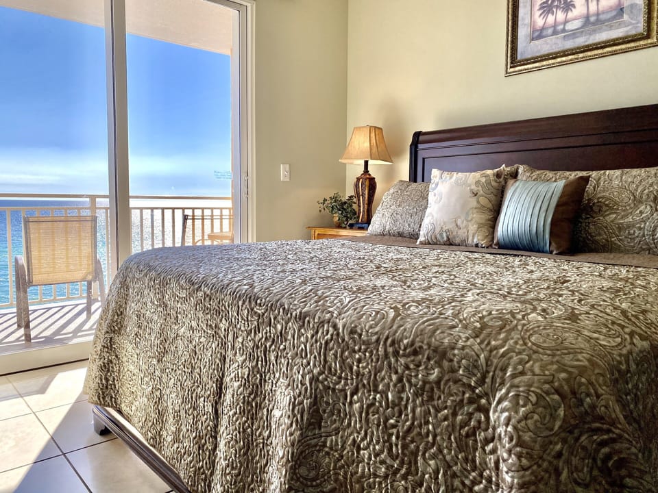 Master Suite featuring a king-sized bed and balcony overlooking the ocean.