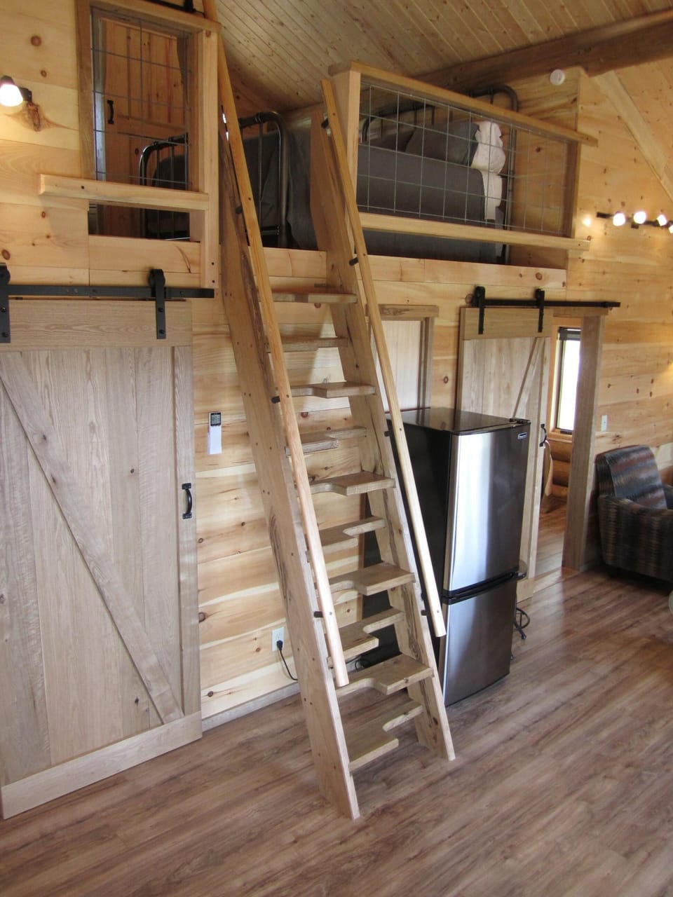 Barn doors open to main floor bedrooms and a ship's ladder leads to loft bedroom
