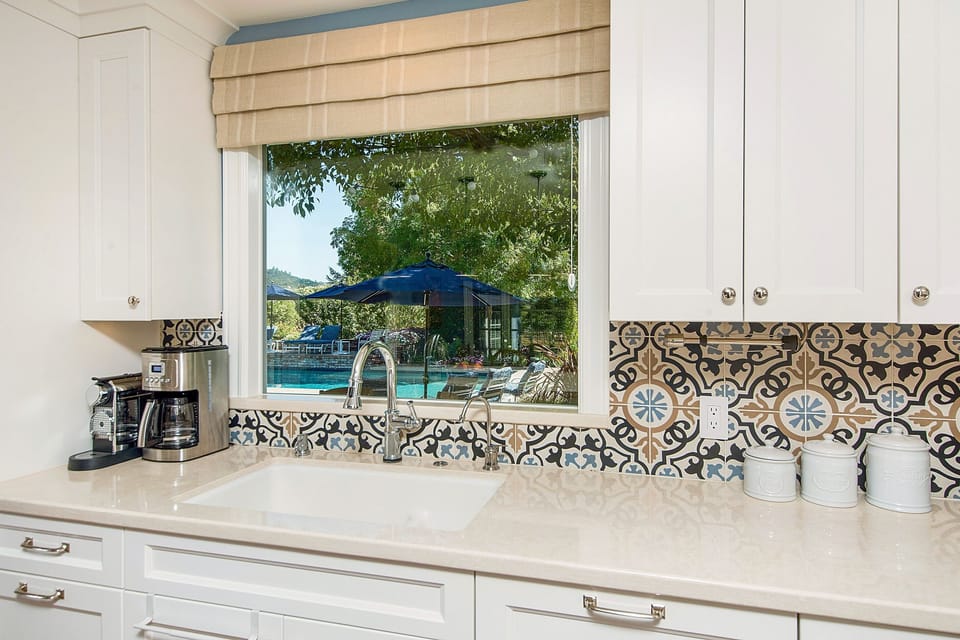 Touch operated faucet, huge sink, with view to patio, pool, and garden.