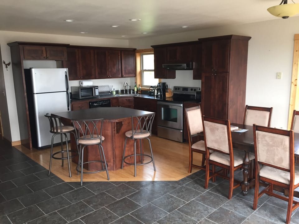 Open Kitchen with dining table (seats 6) and island (seats 3).