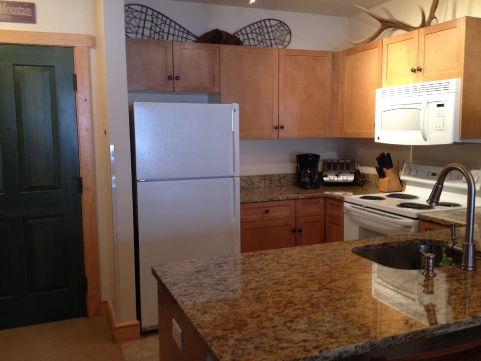 Fully-equiped kitchen with granite countertops.