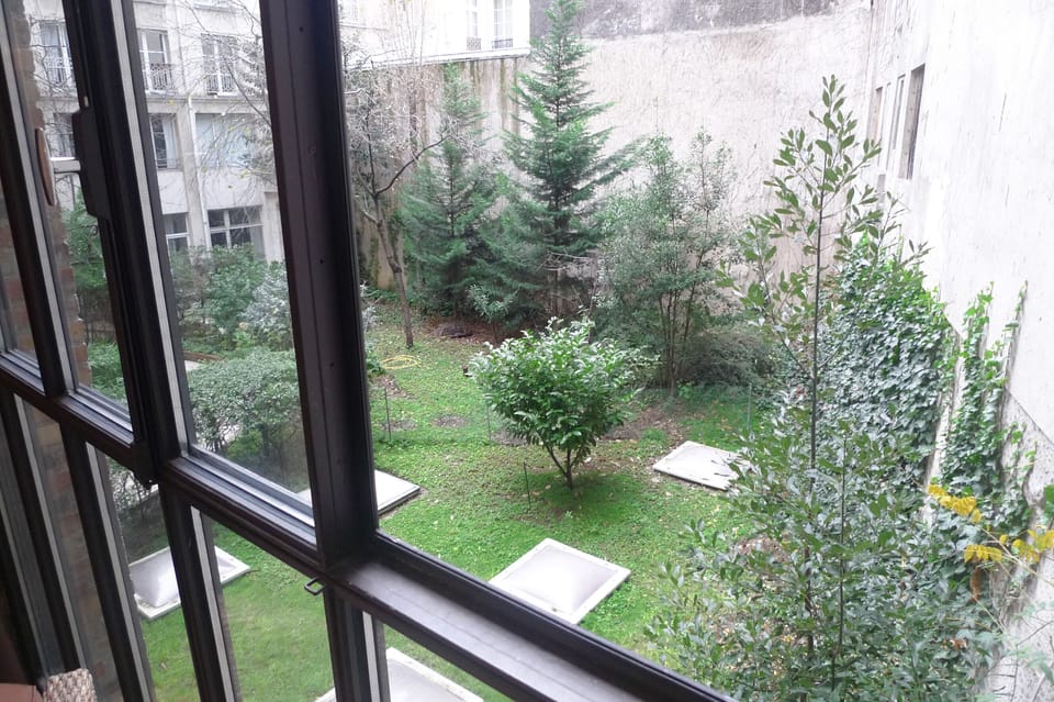 View over the greeneries in the quiet courtyard from the bay window