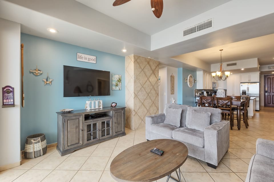 Living area w/flat screen tv and grey couch and loveseat