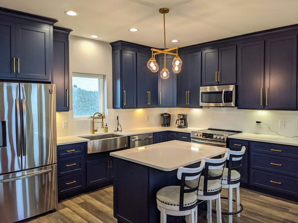 Newly renovated fully stocked kitchen, navy cabinets, white quartz countertops