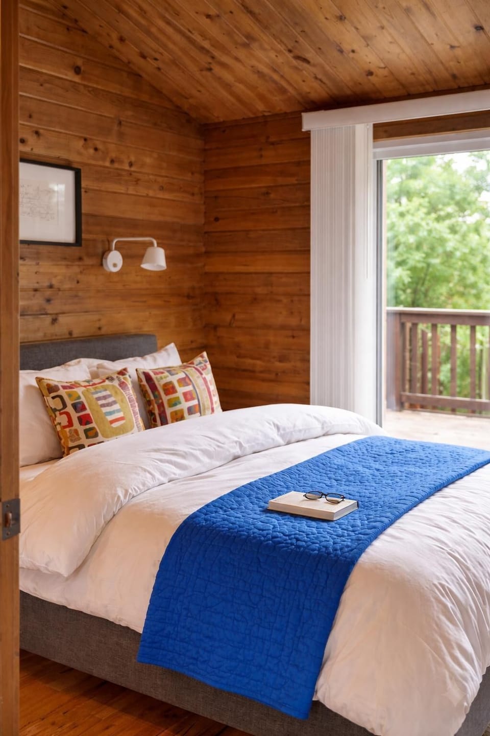 A calm, light-filled bedroom with direct access outside—perfect for slow mornings and restful nights near the shore