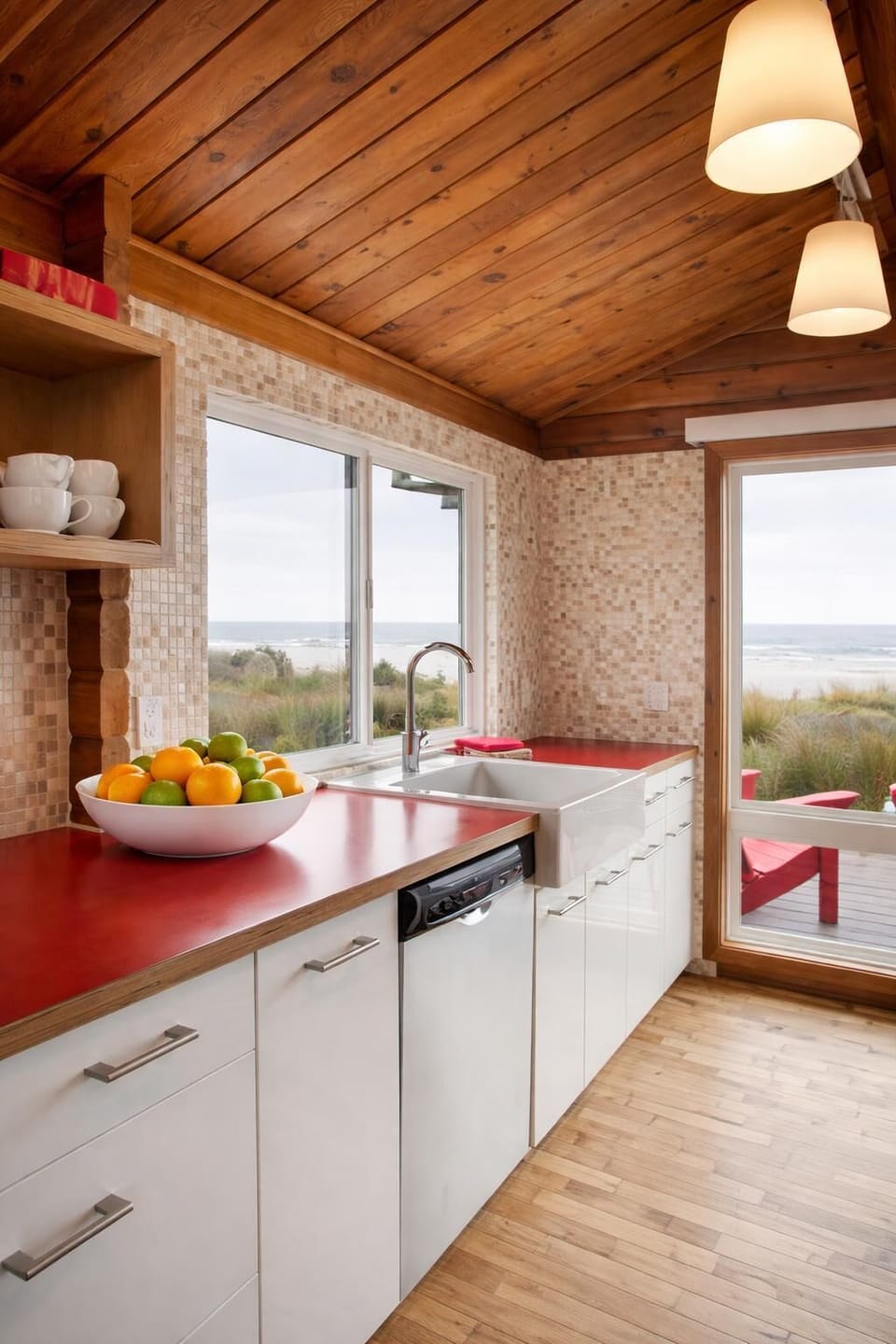 Ocean-view kitchen in this modern cabin—warm wood, clean lines, and a natural connection to the beach just outside