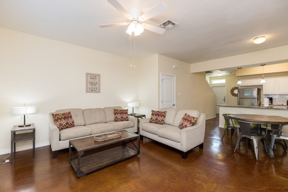 Unwind in your spacious open-plan living area with plush seating, gleaming polished floors, and modern touches throughout.