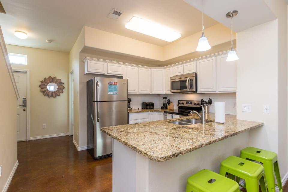 Cook up your favorite meals in this bright, modern kitchen featuring granite counters, stainless appliances, and cheerful breakfast bar seating.