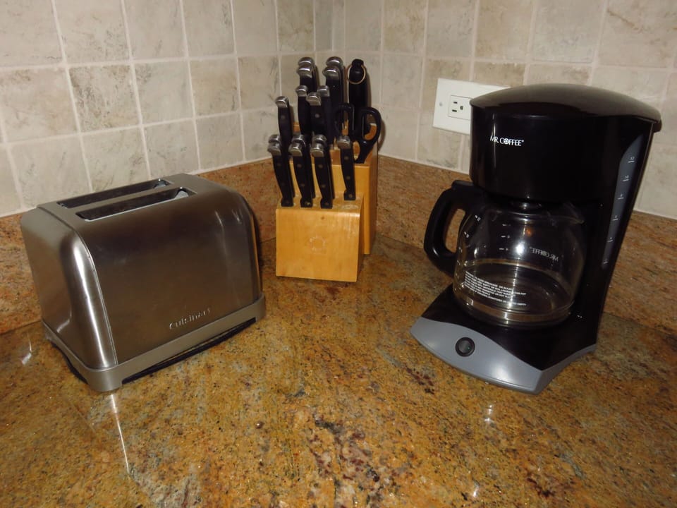Kitchen has coffee maker, knives, toaster, microwave, stovetop/oven, blender...