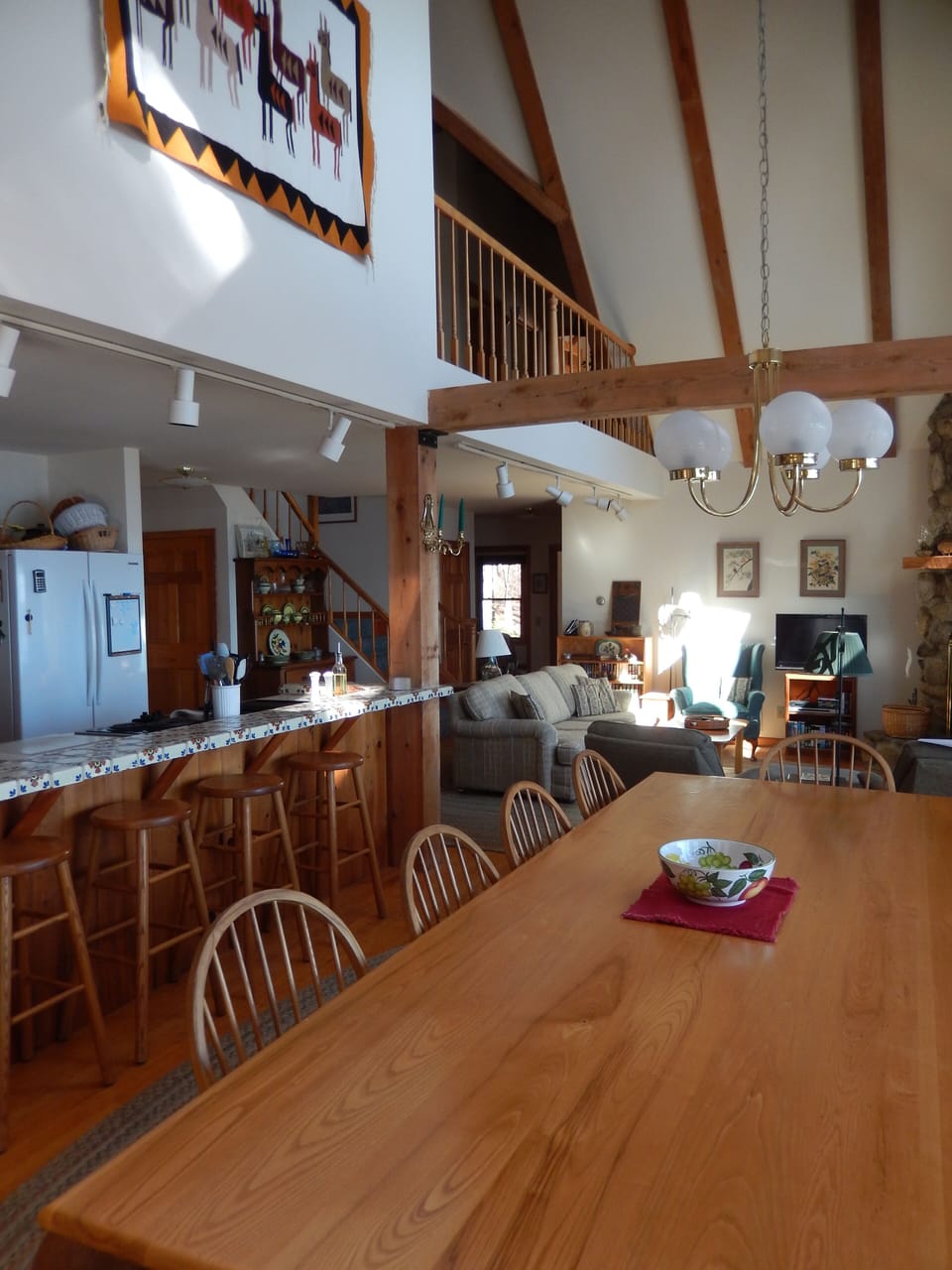 Looking from the dining area to ward the sitting area and loft above.