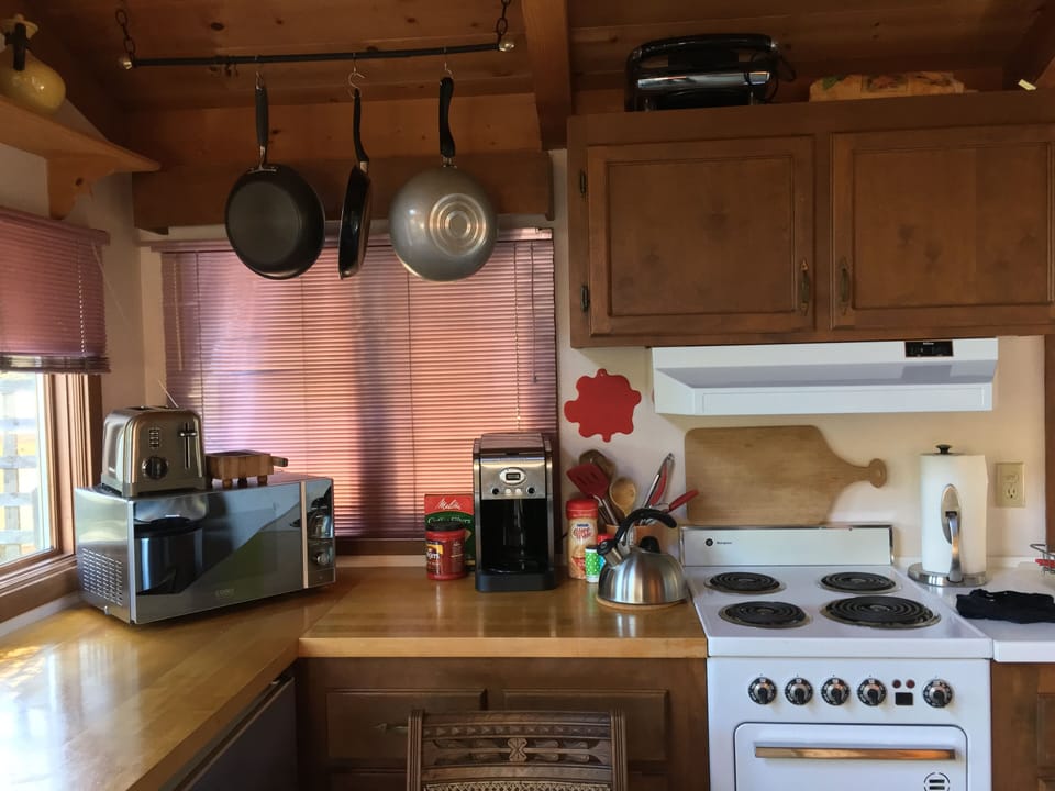 Kitchen with microwave, toaster, coffee maker, stove.