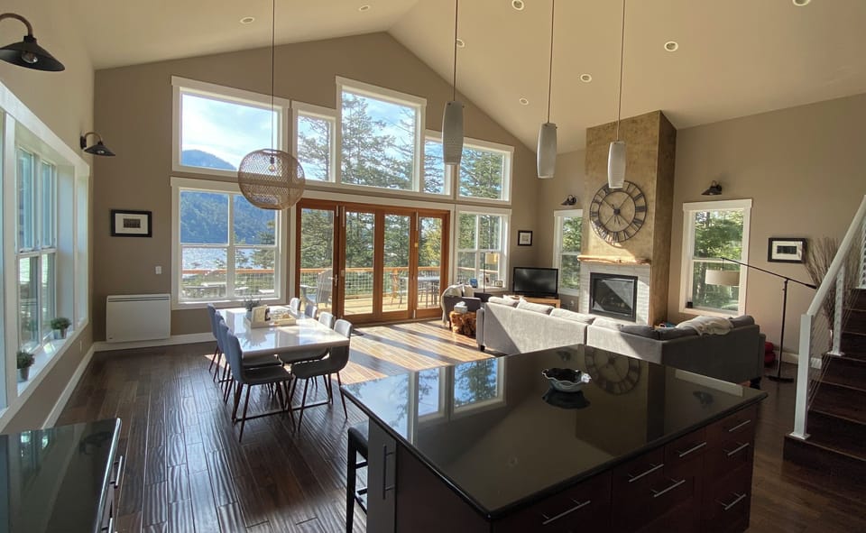 Open plan living, dining and kitchen with 12’ folding doors to deck