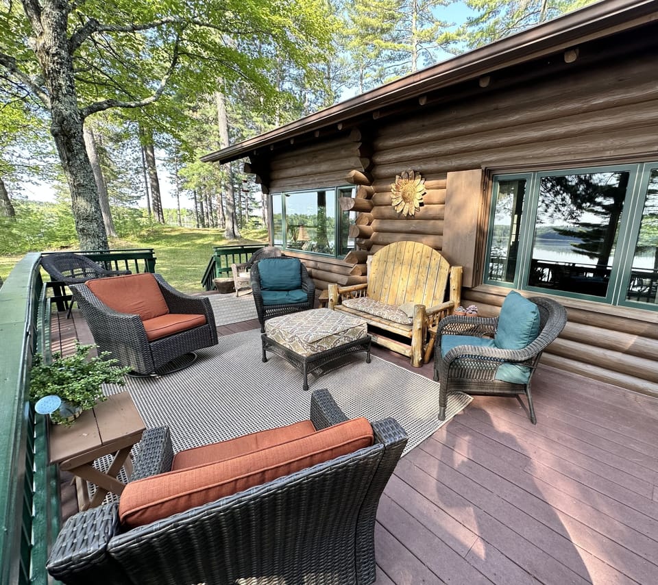 Deck off of kitchen overlooking fire pit and lake with seating for 8