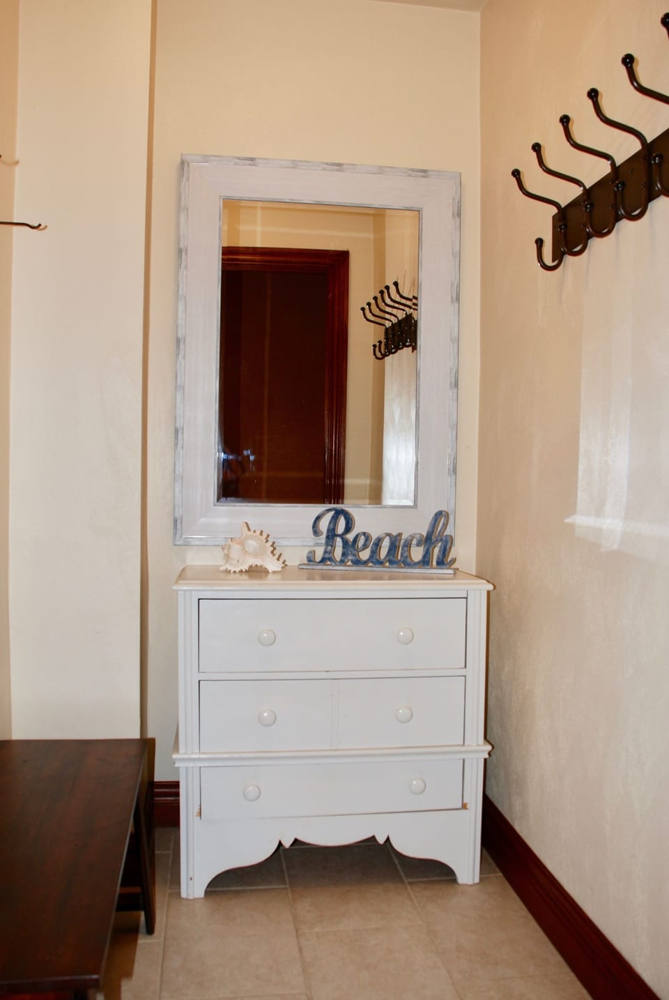 Open closet from garage with many hooks for hats, bathing suits, towels, etc.