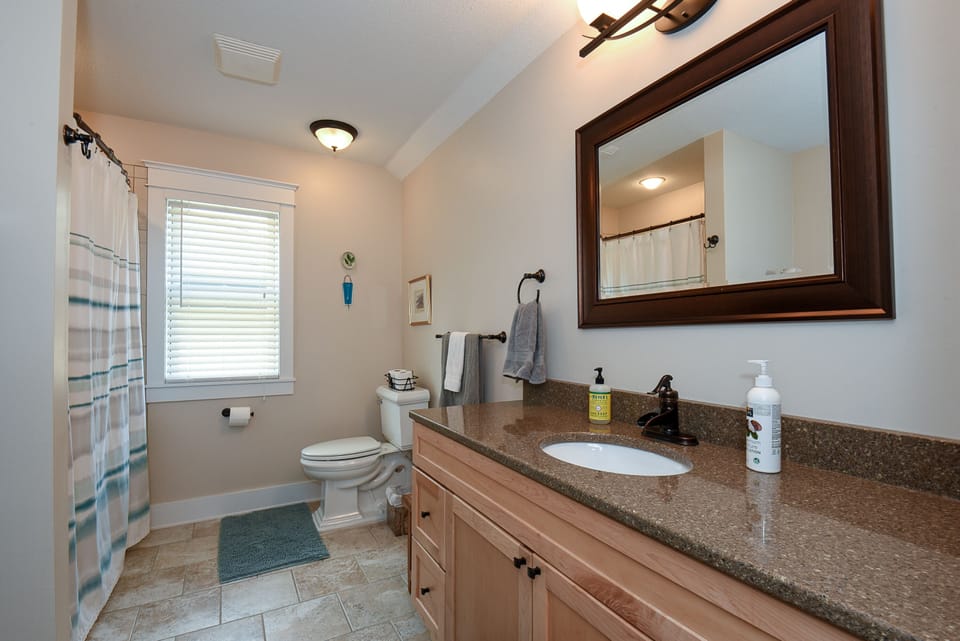 Shared upstairs bathroom with full tub and shower, plus connected laundry.