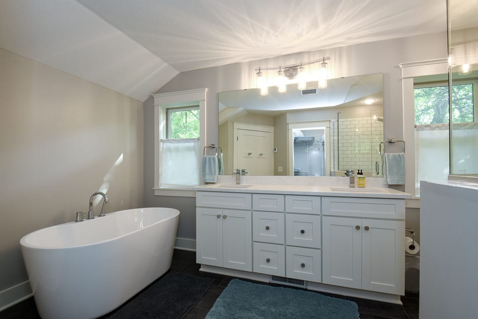 Master bath with soaking tub, walk-in shower and park views.