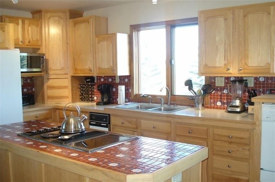 Spacious kitchen with breakfast nook overlooking patio, pond and mountains.