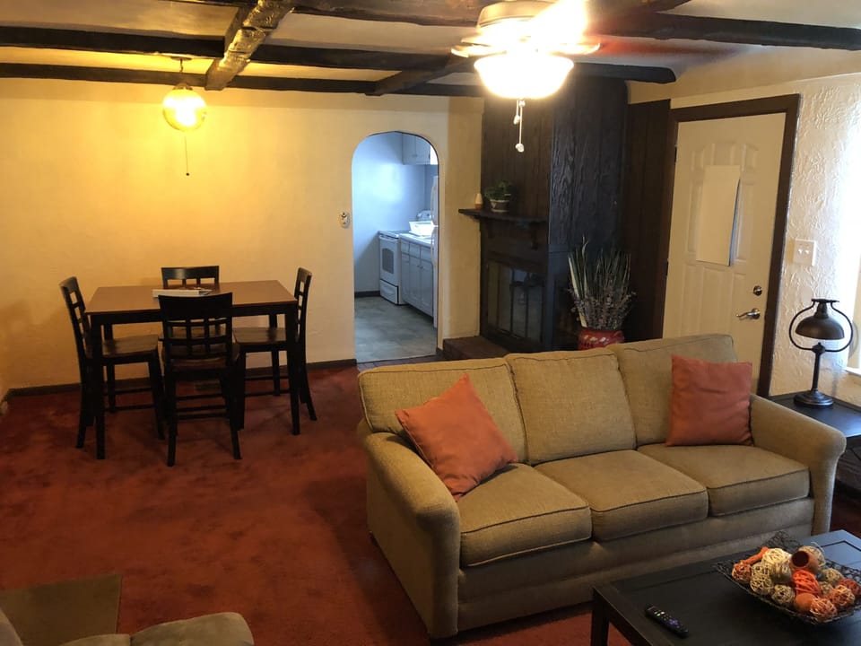 Living Room with pullout couch, futon, 55” Smart TV, and dining room table. 