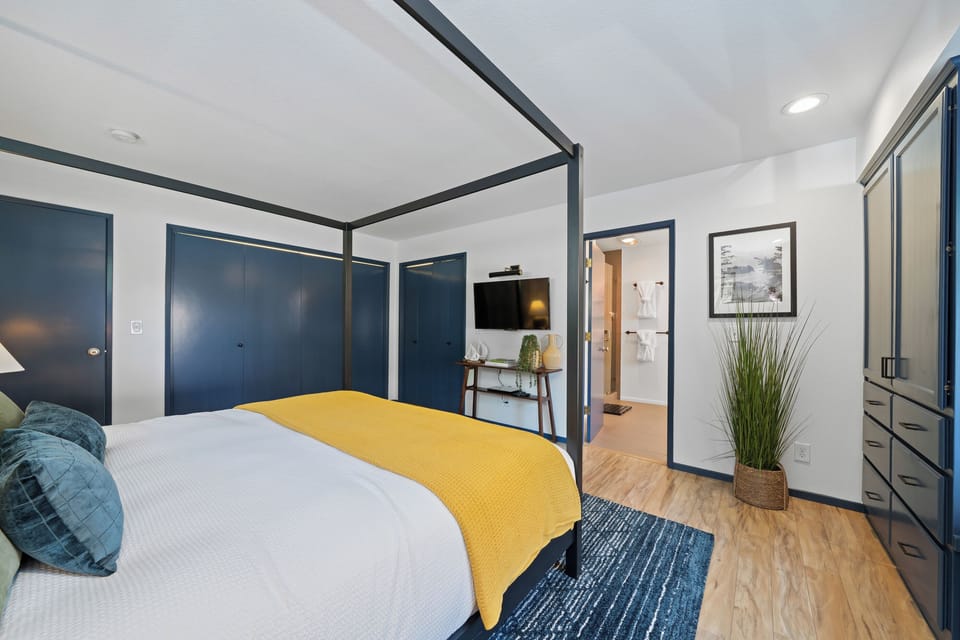 Spacious primary suite featuring a king canopy bed, custom built-ins, and a private ensuite—designed for comfort and relaxation.