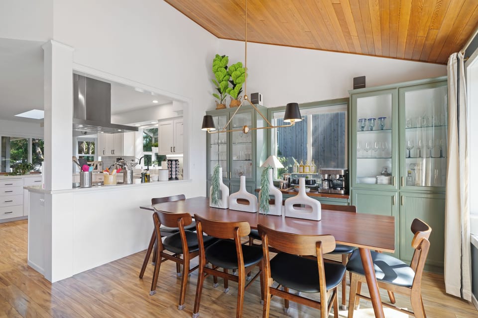 Sun-filled dining area with vaulted wood ceilings and sliding doors that open to the deck—perfect for indoor-outdoor living and easy entertaining.