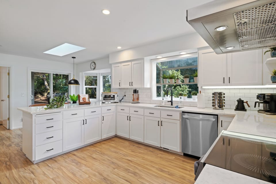 Bright, modern kitchen with stainless steel appliances, ample counter space, and an open layout that flows seamlessly into the dining and living areas.