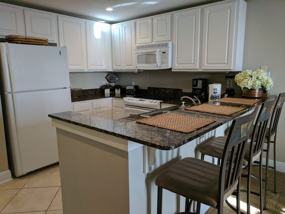 Kitchen bar with granite top, fully equipped kitchen.