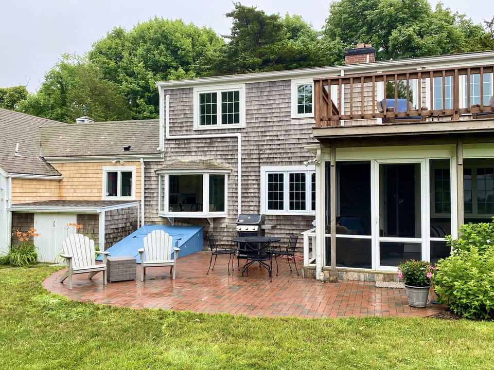 Brick patio with propane grill and outdoor seating. 