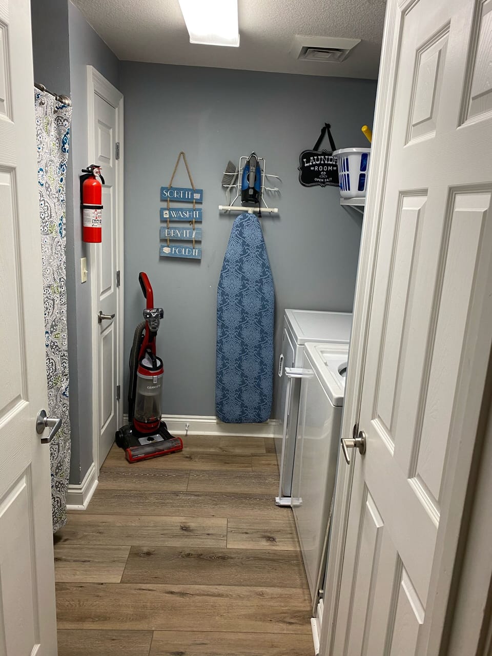 Laundry room with full size washer, dryer, iron & ironing board and drying rack 