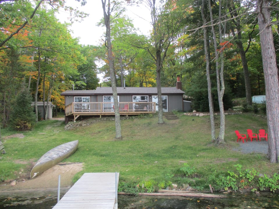 View of cotage from the dock. Gentle slope to Mann Lake. 