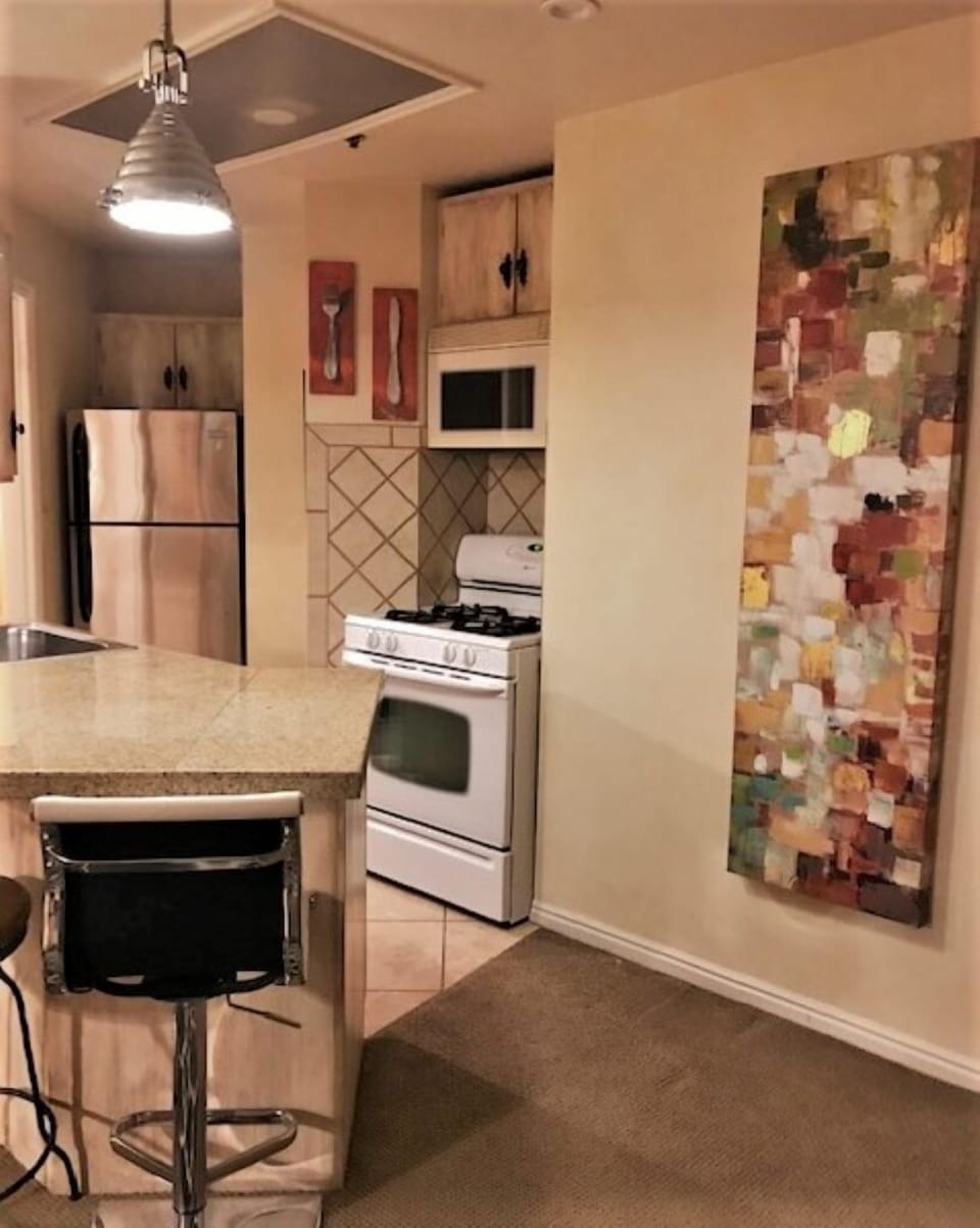 Kitchen with stove, refrigerator, dishwasher, microwave, full set-up to cook.