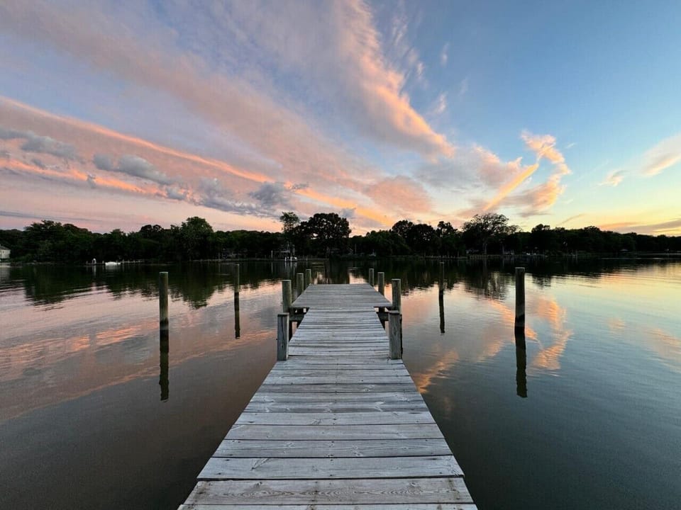 Enjoy soft evening skies and mirror-like reflections from the waterfront pier.