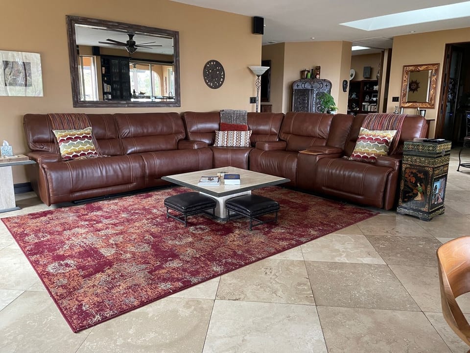 Living room sofa with 4 recliners, cup holders, coffee table and two stools.