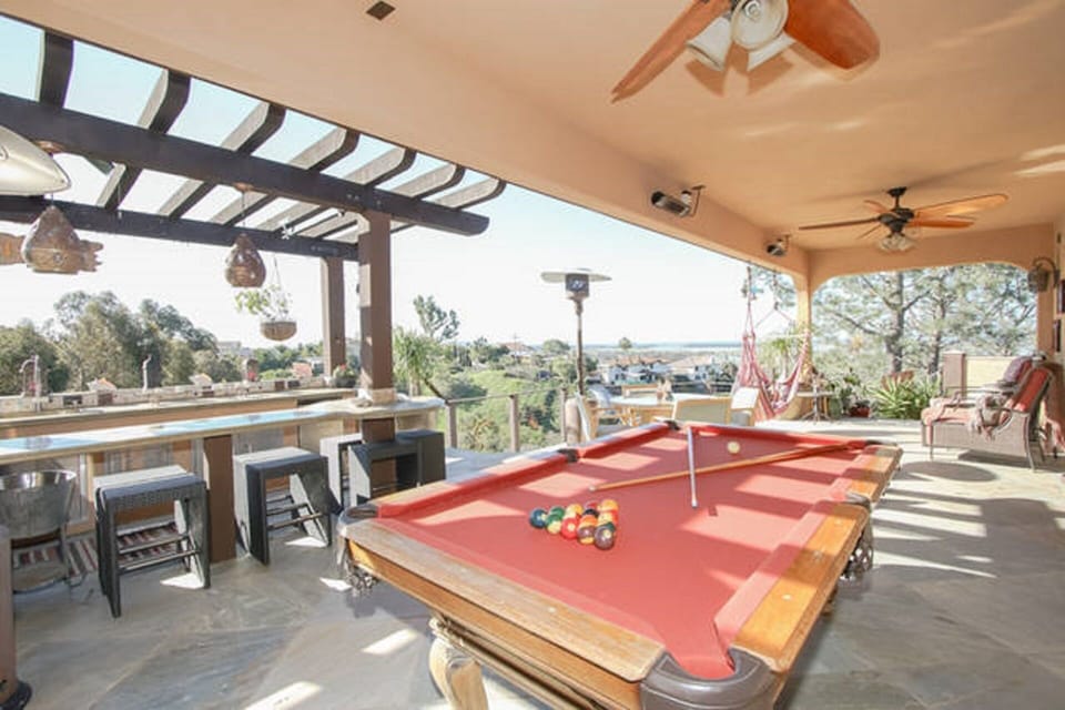 Outdoor living, deck with water view,  darts, pool table, heaters & bbq island.