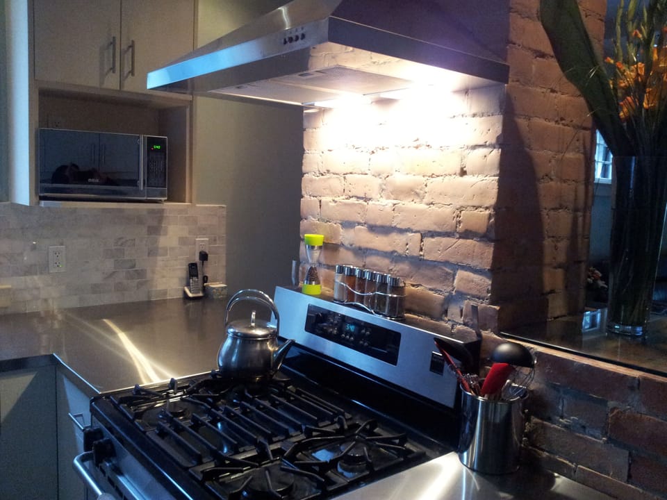 Gas stove and oven is positioned nicely for entertaining guests while cooking