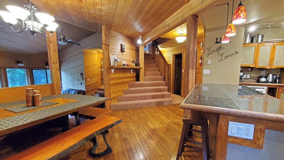 Hub showing kitchen island, dining table, sunken living room, stairs to bedrooms