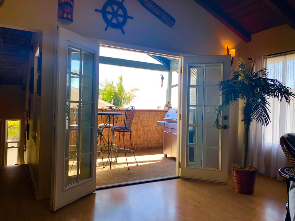 French doors lead to ocean view dining with propane bar-b-q