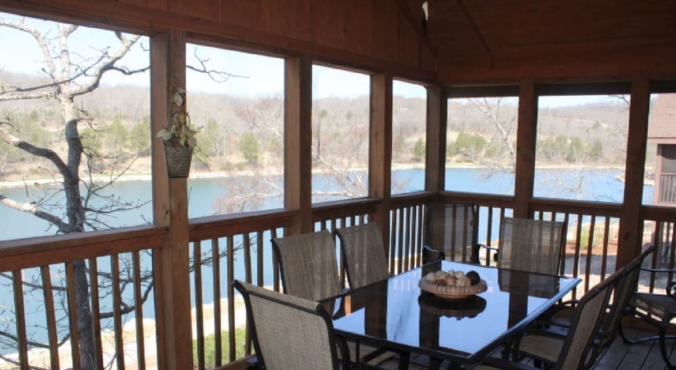 Our beautiful screened in back porch overlooking the lake with seating for 10