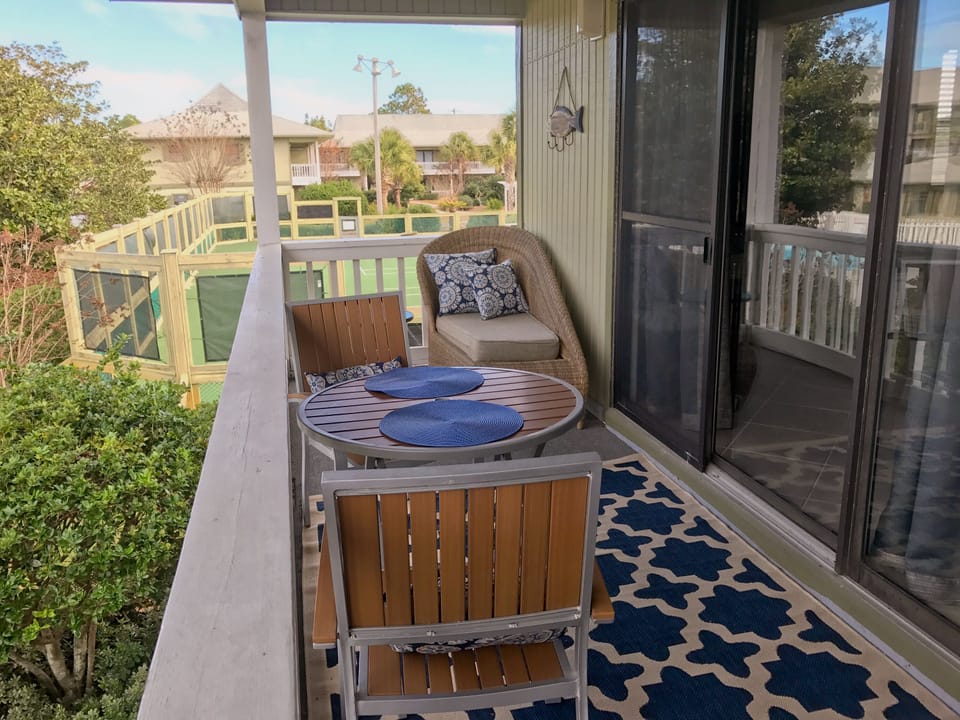 Furnished patio overlooking tennis courts. 