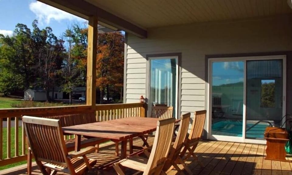 Covered deck with grill next to the pool overlooking mini golf & tennis courts