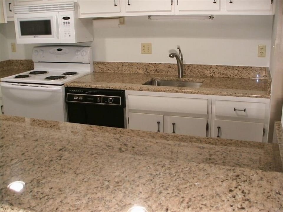 Kitchen with granite, below counter sink and high arch pull out sprayer faucet.