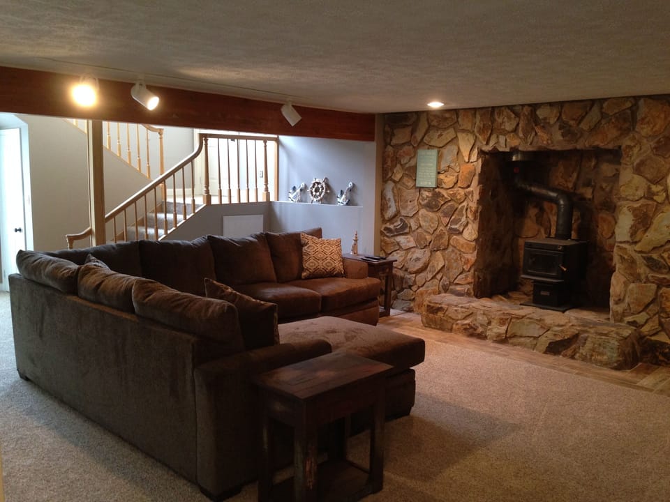 Basement with large sofa and flat screen TV with Dish.  Also walkout to patio.