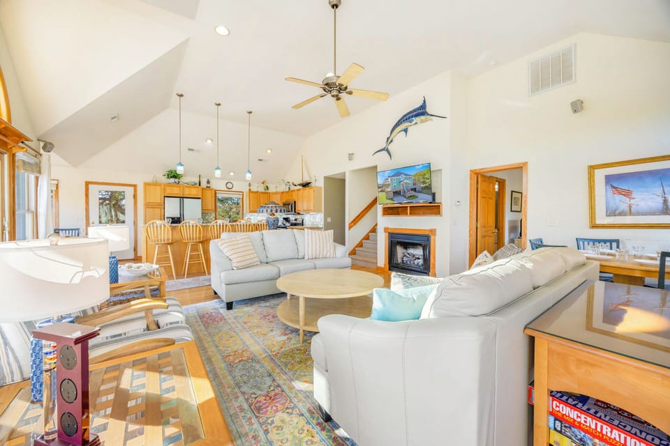 Relax in your spacious coastal living room with vaulted ceilings, cozy fireplace, and comfortable seating perfect for unwinding after beach days.