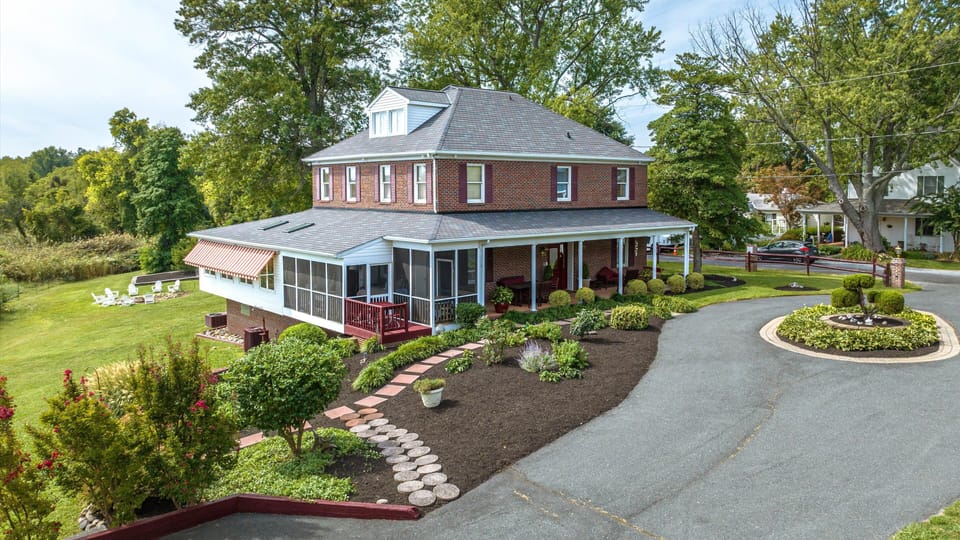 Sun room on left, NE screened porch, front porch. House fire pit in background