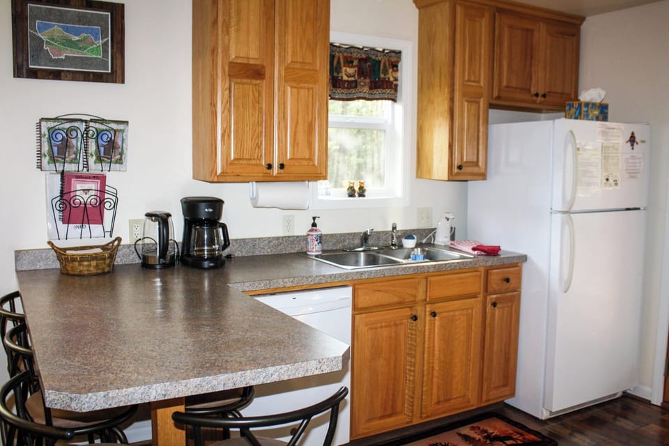 Kitchen with double sink, refrigerator, dishwasher and all dishware provided.