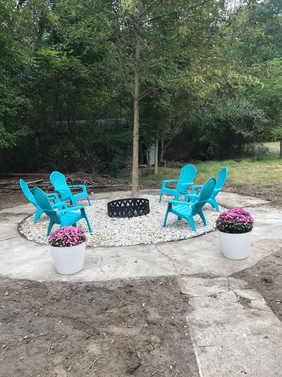 Backyard features a rear patio with dining area, fire pit & outdoor shower