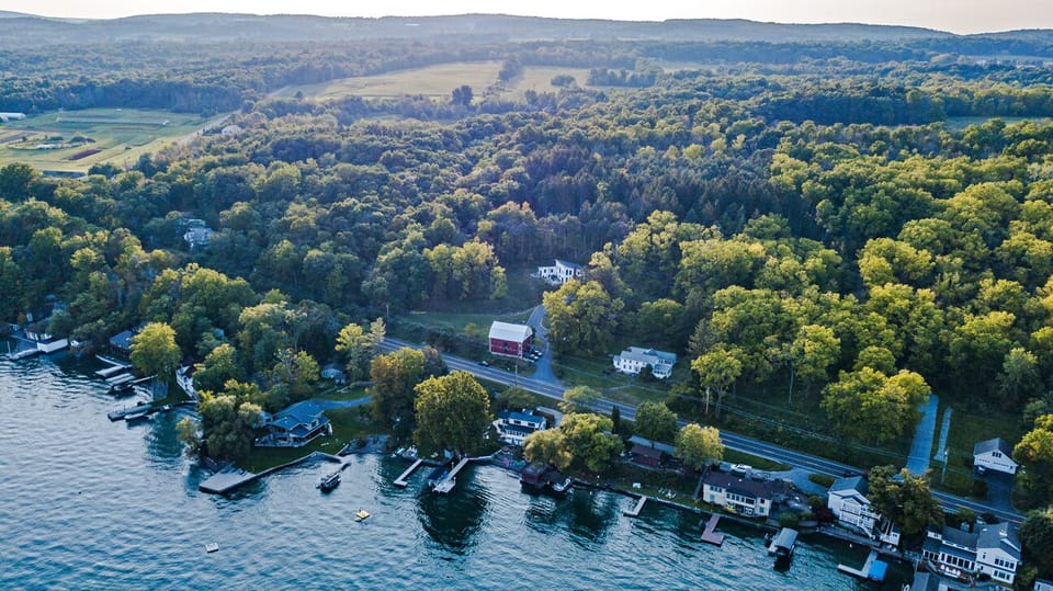 aerial view of white farmhouse to right of Red barn